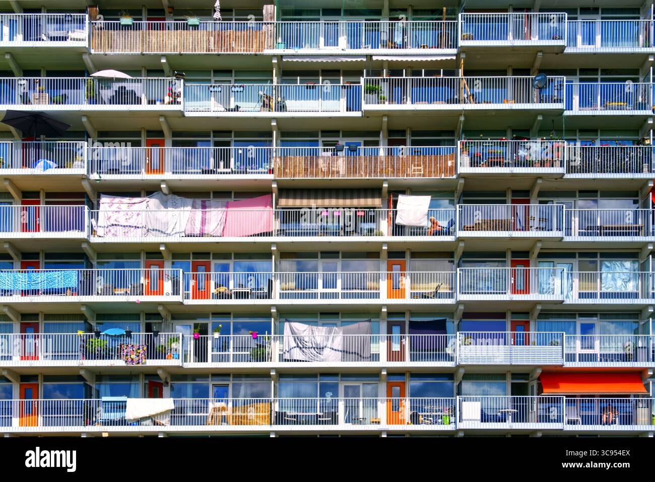 Facciata di un edificio residenziale con balconi e lavanderia che si stende all'asciutto, mostrando vita urbana e stile di vita degli appartamenti Foto Stock