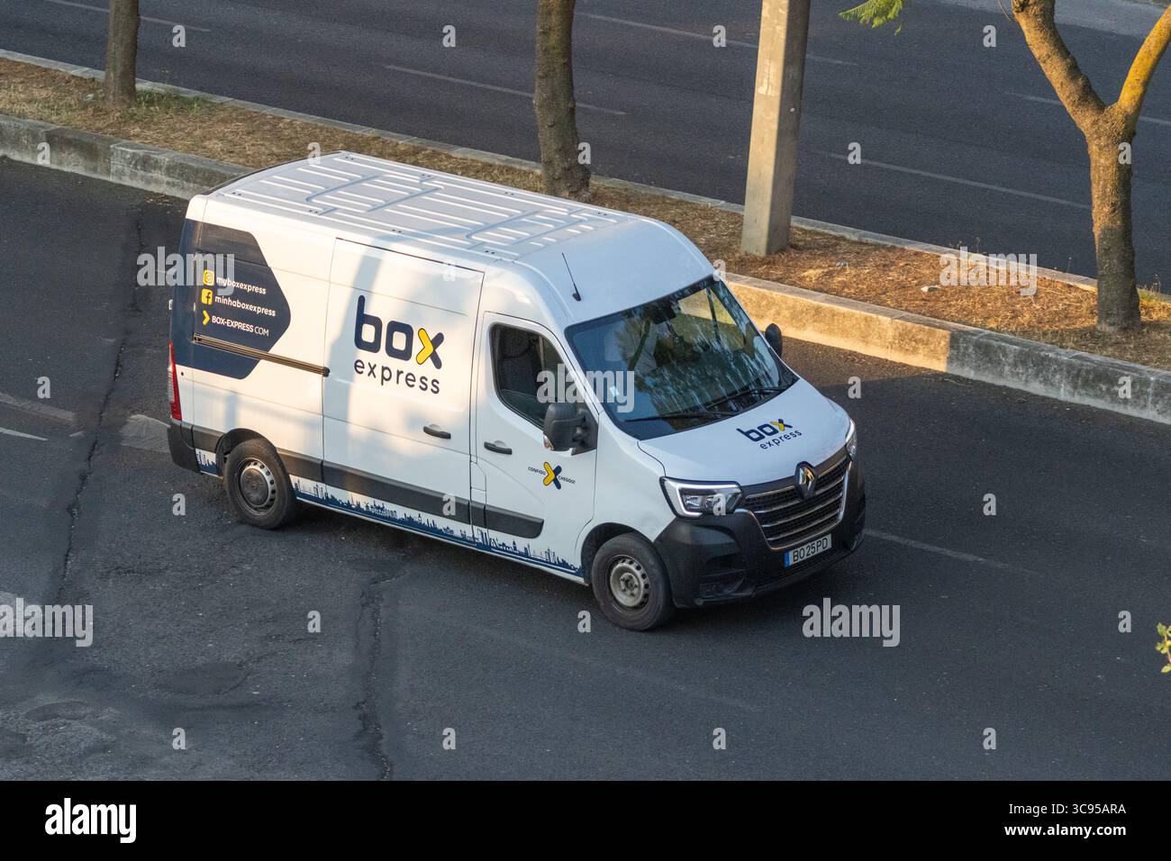 Furgone bianco renault master con marchio Box Express che guida su una strada urbana, offrendo un servizio di consegna efficiente Foto Stock