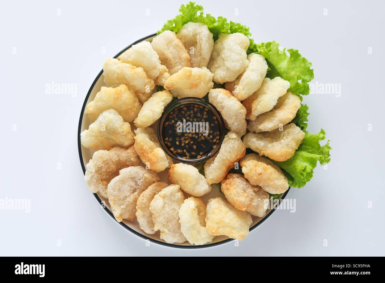 Vista dall'alto verso il basso di Cireng, un popolare spuntino salato indonesiano a base di farina di tapioca, ordinato su un piatto bianco. Accompagnato da una salsa per immersione. Foto Stock