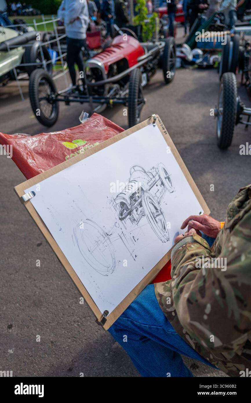 Pittore che disegna un'auto sportiva monoposto GN katipo d'epoca pre-bellica nel paddock presso il VSCC Prescott Hill Climb Meeting. Foto Stock