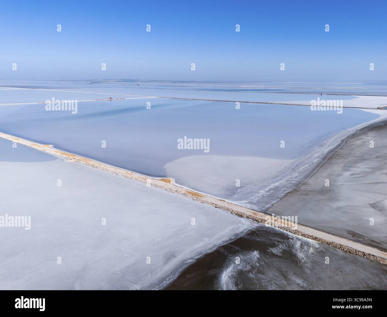Un vasto lago salato sotto un cielo azzurro limpido, con semplici linee geometriche e passerella pedonale, vista aerea, lago salato, Tuz Goelue, posizione tra Konya, Aksar Foto Stock