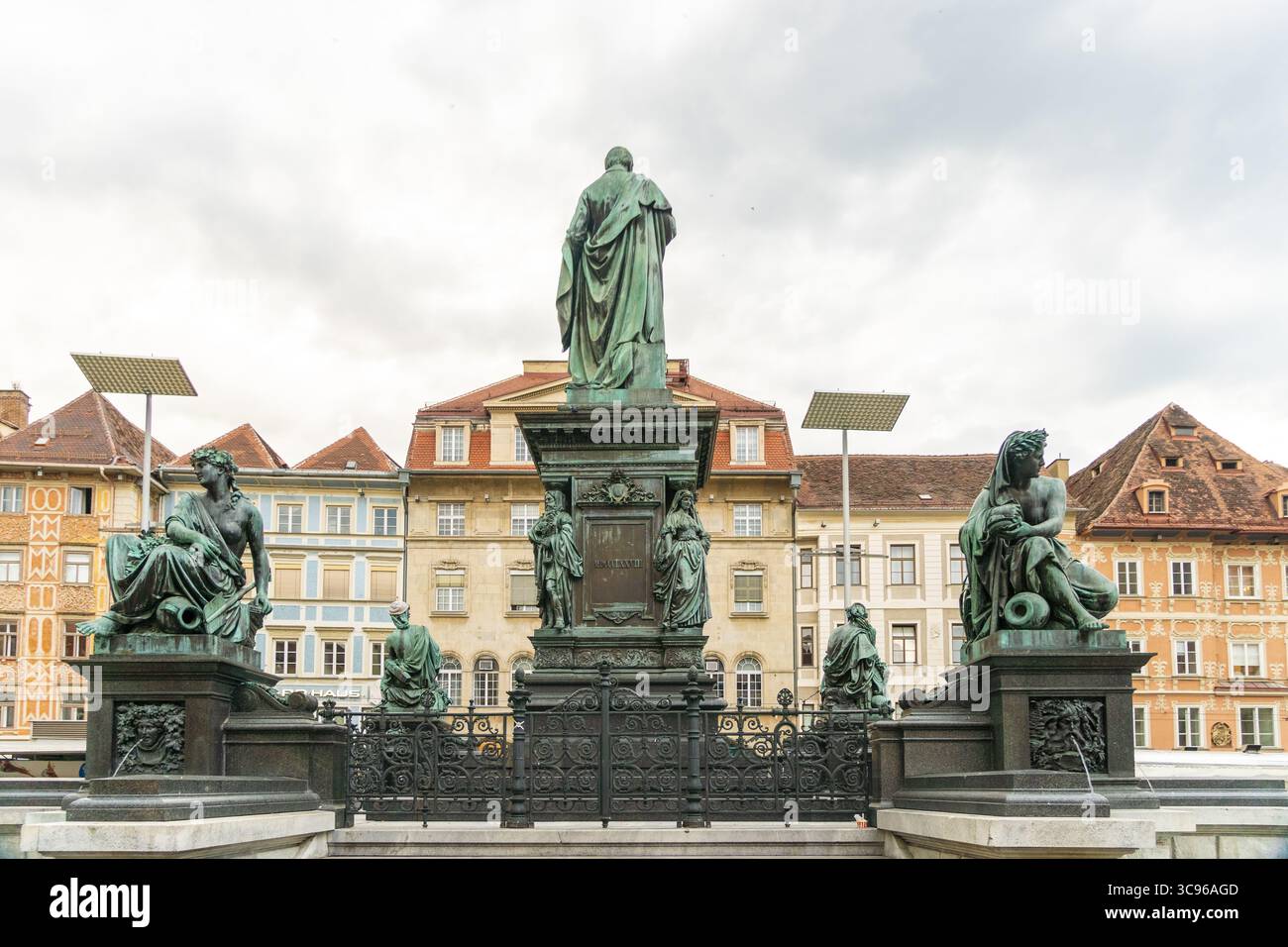 Vista della fontana Erzherzog Johann, un monumento in bronzo impressionante sullo sfondo di edifici colorati e cieli sovrastati, Graz, Steiermark, Austria. Foto Stock
