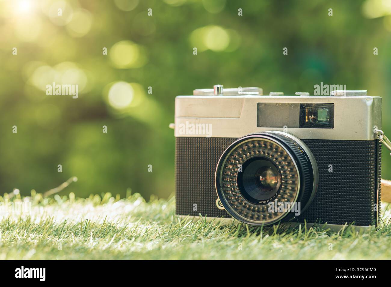 primo piano di una fotocamera compatta classica d'epoca all'aperto verde con spazio di copia per il testo, concetto di stile di vita per hobby della fotografia rétro Foto Stock
