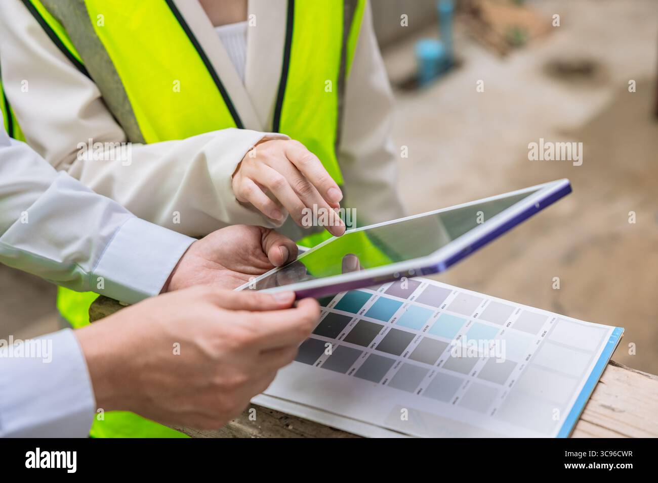 primo piano ingegnere edile con progettazione di interni che guarda lo schermo di un tablet per il software di cartografia a colori Foto Stock