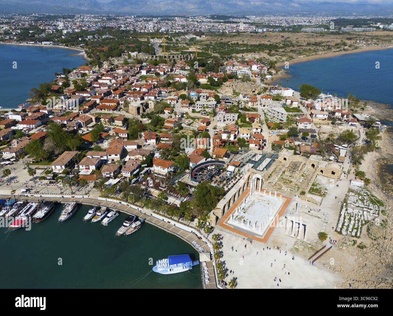 Vista pittoresca di una città costiera con antiche rovine e tetti rossi sul mare, vista aerea, porto e Tempio di Apollo, Side, Manavgat, Antalya pro Foto Stock
