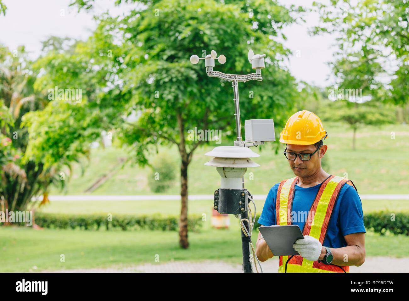 Uomo tecnico addetto alla raccolta dell'inquinamento atmosferico, monitoraggio meteorologico, dati relativi al vento provenienti dalla stazione di rilevamento all'aperto Foto Stock