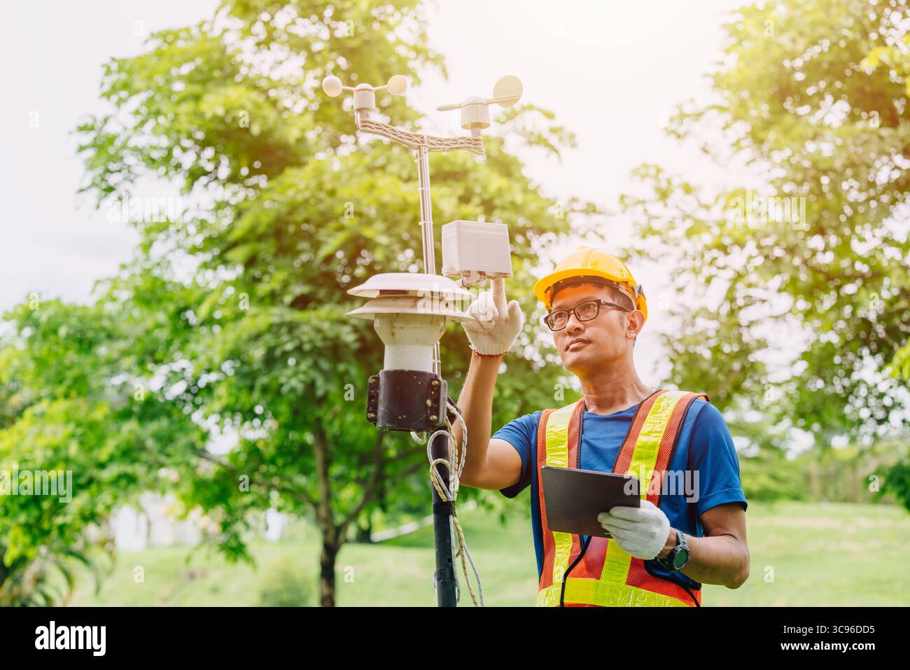 Uomo tecnico addetto alla raccolta dell'inquinamento atmosferico, monitoraggio meteorologico, dati relativi al vento provenienti dalla stazione di rilevamento all'aperto Foto Stock