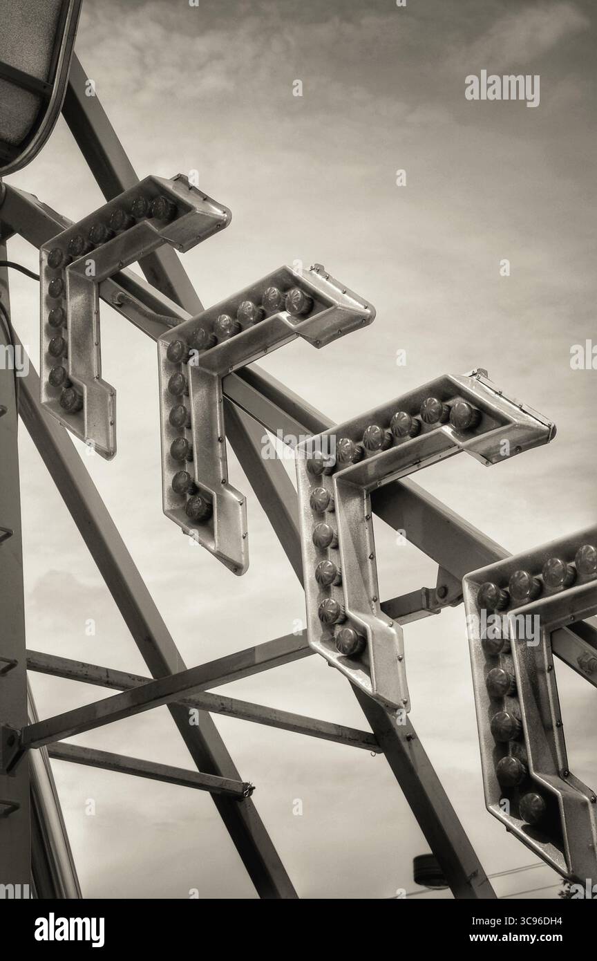 Luci a freccia su un giro di carnevale in tonalità seppia Foto Stock