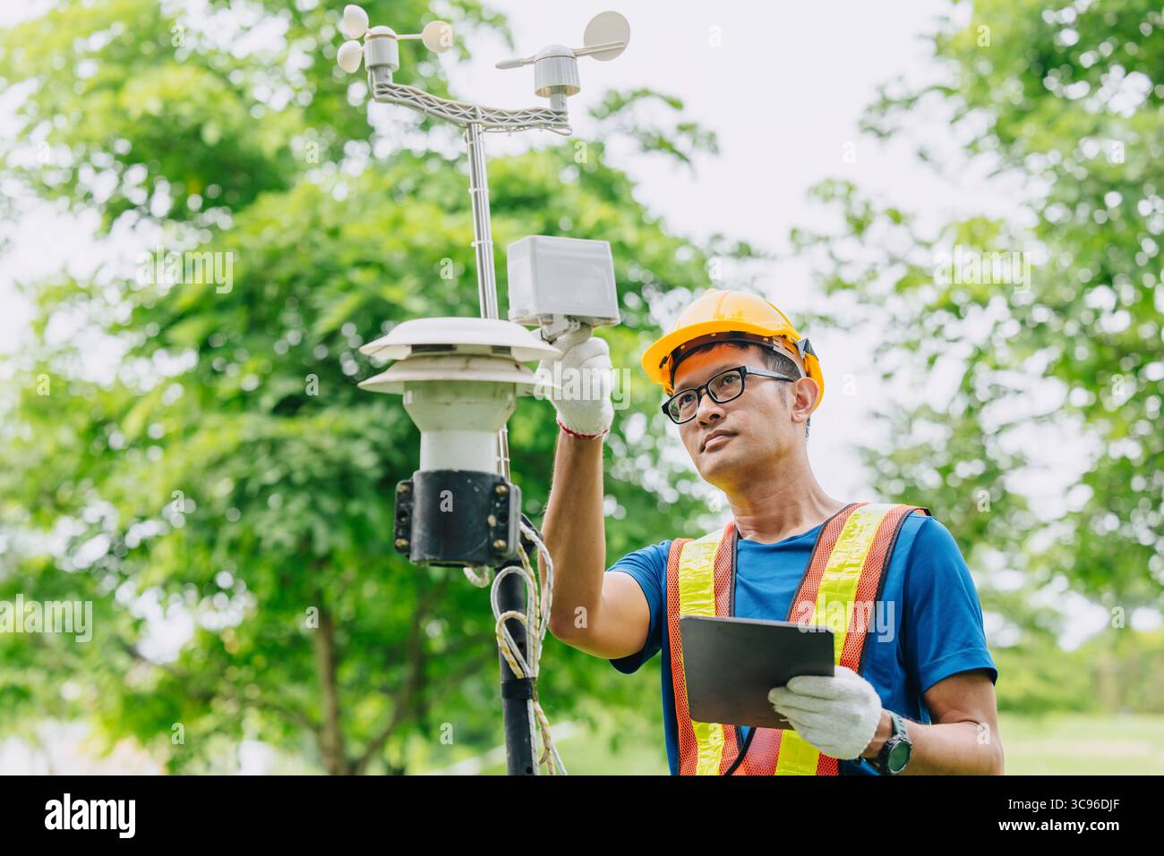 Uomo tecnico addetto alla raccolta dell'inquinamento atmosferico, monitoraggio meteorologico, dati relativi al vento provenienti dalla stazione di rilevamento all'aperto Foto Stock