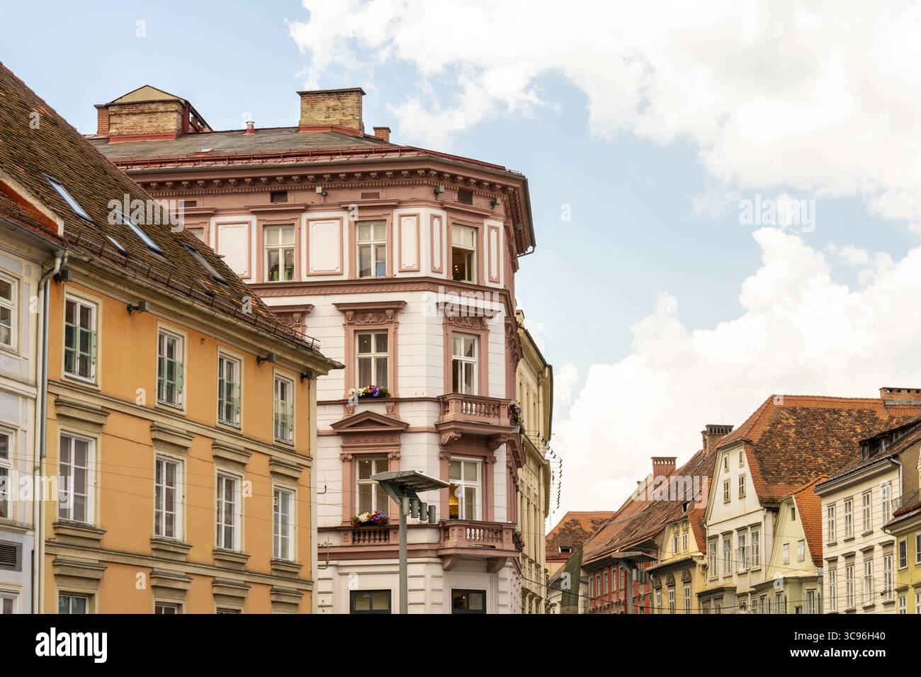 Vista di edifici colorati con intricati dettagli architettonici sotto un cielo parzialmente nuvoloso, che mostrano il fascino dei paesaggi urbani europei, Graz, Graz, Austria. Foto Stock