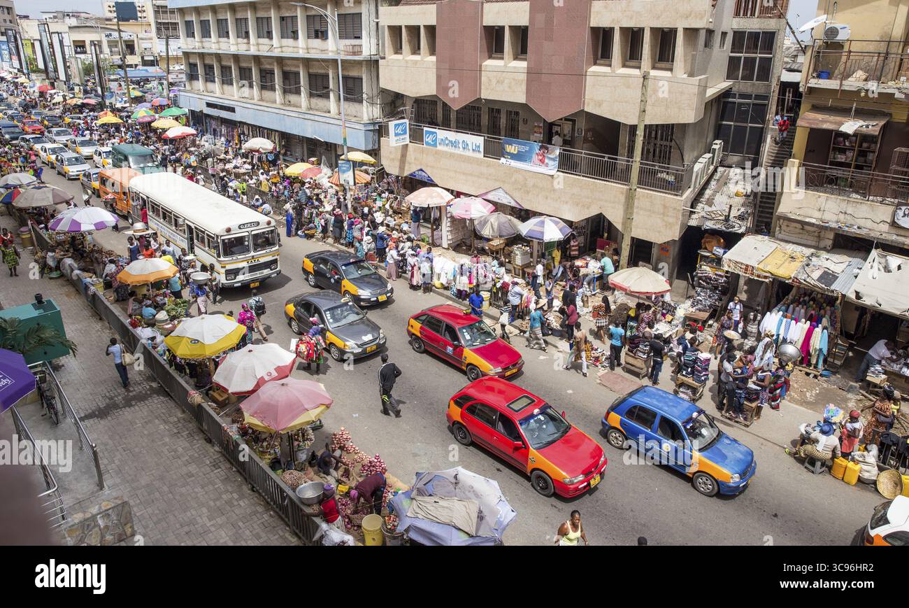 Accra, Ghana - 27 maggio 2017: Veduta di una vivace strada brulicante di venditori, automobili e pedoni sotto il caldo sole ghanese, che crea un vivace arazzo della vita urbana. Foto Stock