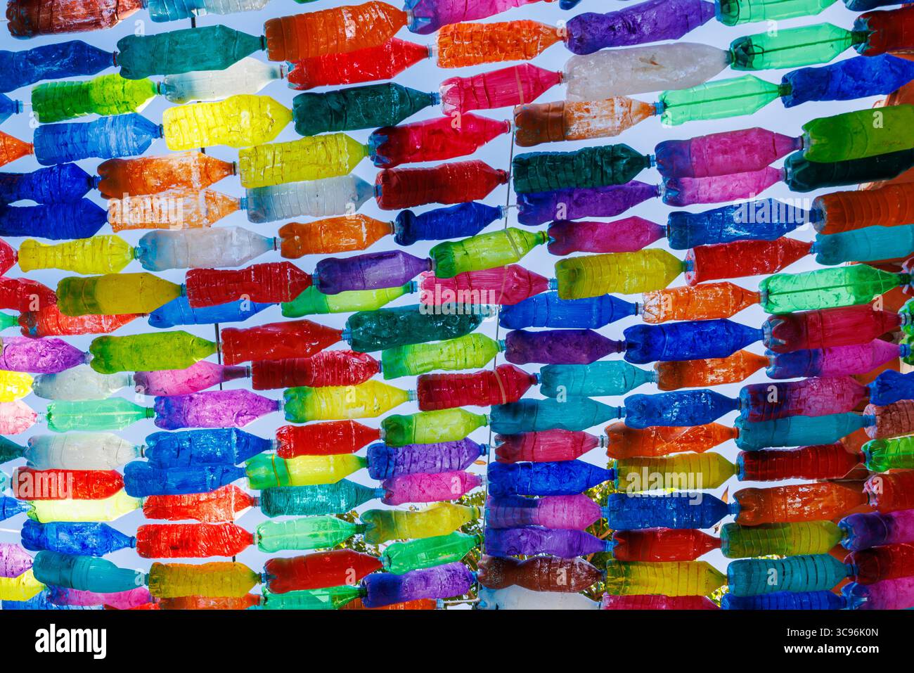 Bottiglie di plastica dai colori vivaci unite come decorazioni stradali. Ghirlande fatte in casa di bottiglie colorate sull'isola di Madeira, Portogallo. Alta qualità Foto Stock