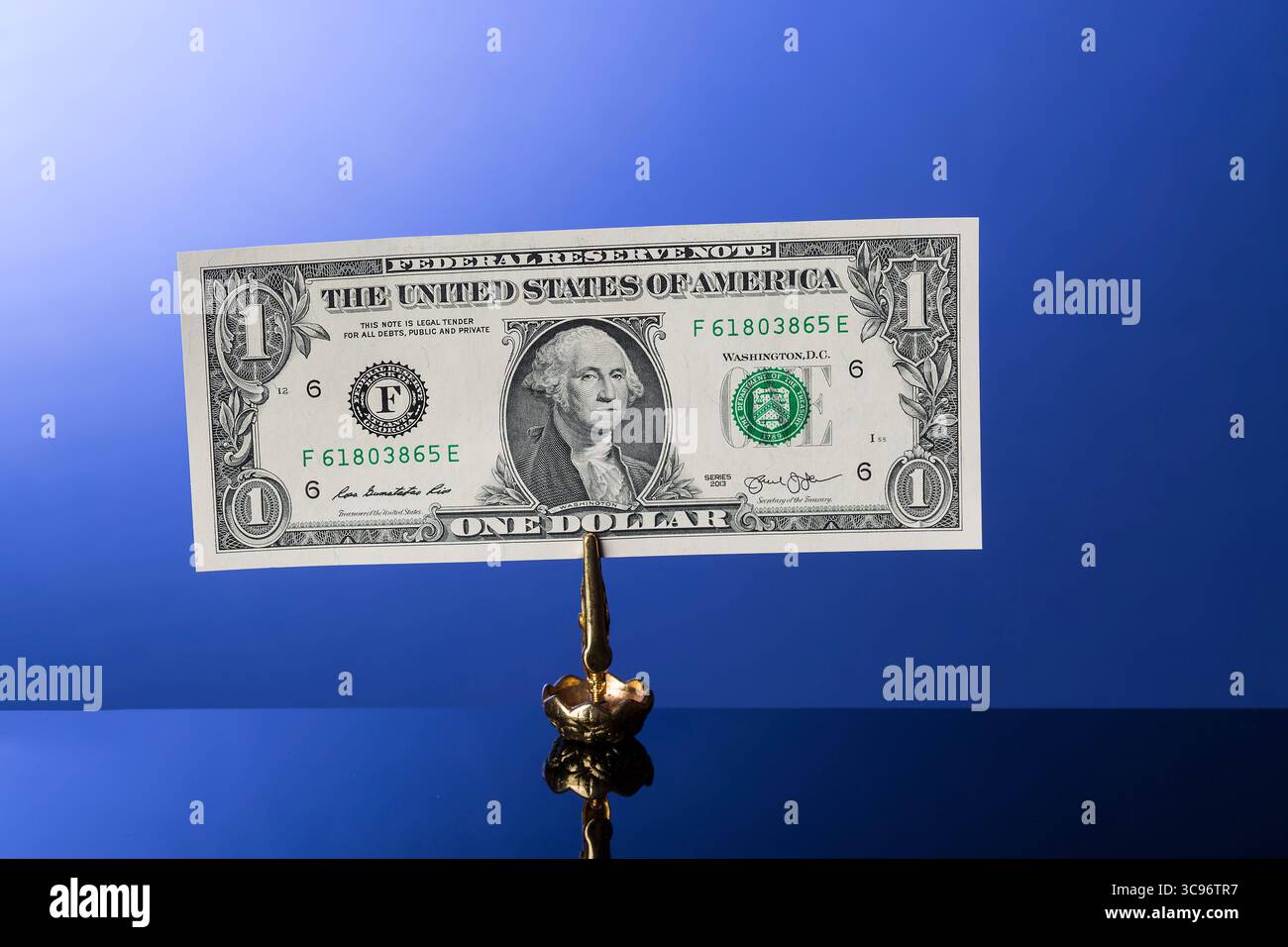 banconota da un dollaro su sfondo blu con riflesso Foto Stock
