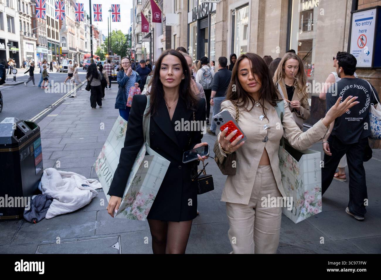 Gli acquirenti e i visitatori di Oxford Street scattano selfie il 7 luglio 2025 a Londra, Regno Unito. Oxford Street è un importante centro commerciale nel West End della capitale ed è la strada commerciale più trafficata d'Europa, con circa mezzo milione di visitatori al giorno ai suoi circa 300 negozi, la maggior parte dei quali sono negozi di moda e di abbigliamento di alta moda. Foto Stock