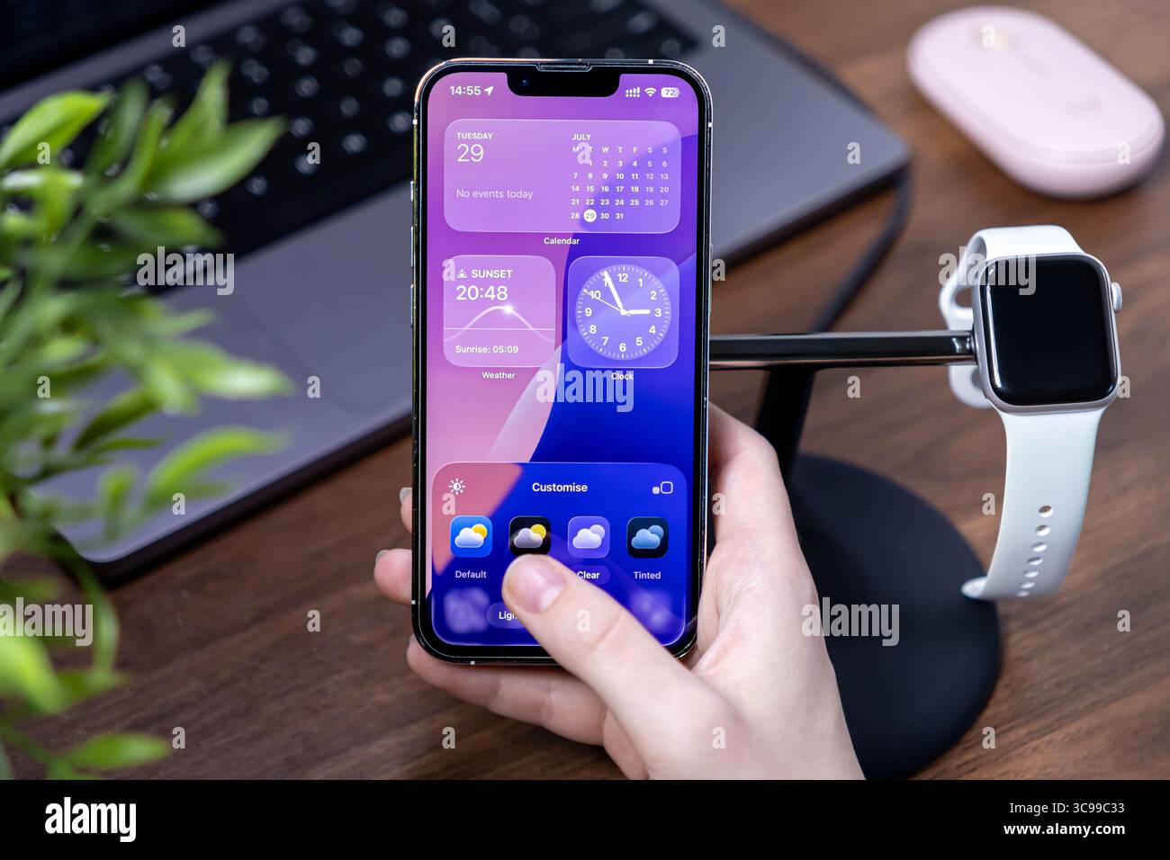 Poznan, Polonia - 29 luglio 2025: Una vista ravvicinata di una mano che interagisce con un iPhone, con ios 26 e schermo in vetro liquido, che mostra i clienti Foto Stock