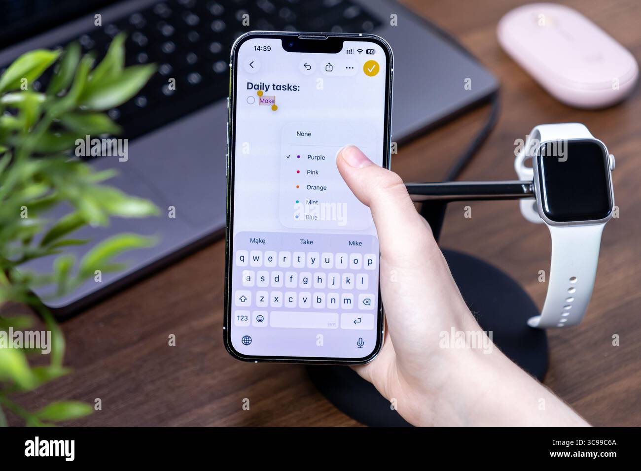 Poznan, Polonia - 29 luglio 2025: Primo piano di una mano che naviga in un'applicazione di elenco attività quotidiane su uno smartphone con ios 26 e schermo a cristalli liquidi, promo Foto Stock