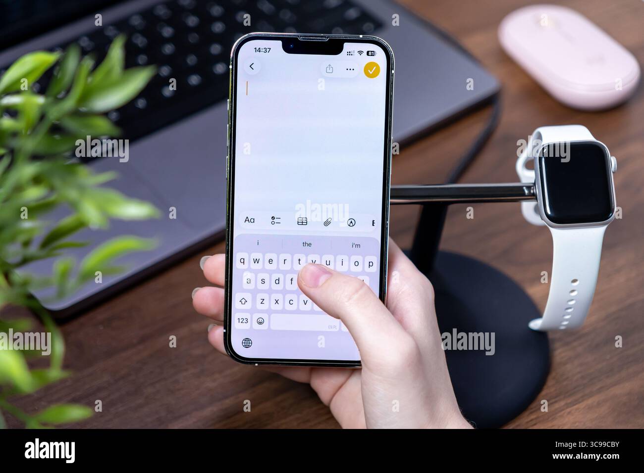 Poznan, Polonia - 29 luglio 2025: Digitazione manuale su uno smartphone con ios 26 e Liquid Glass, che mette in evidenza comunicazioni digitali efficienti e personali Foto Stock