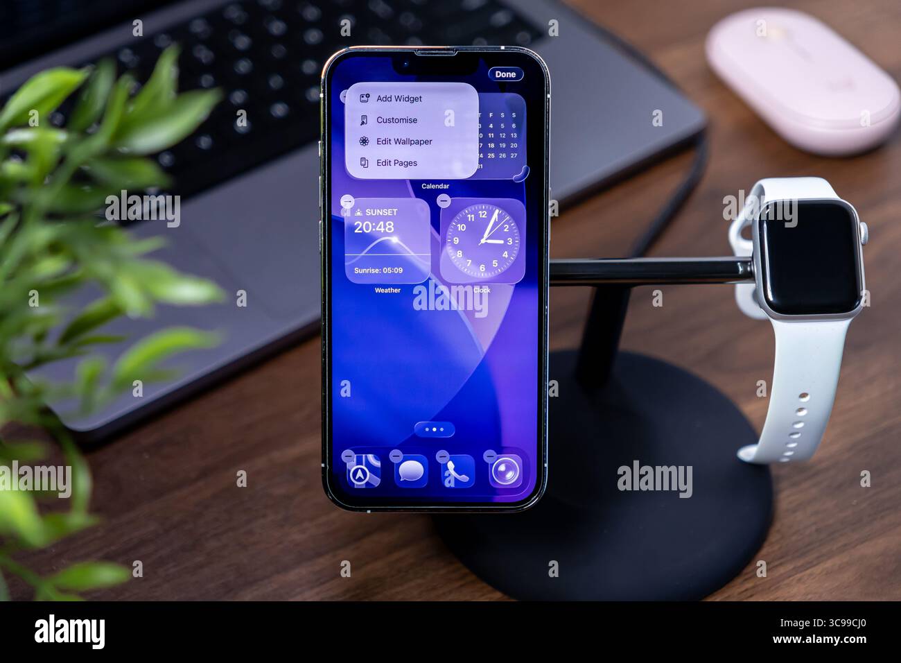Poznan, Polonia - 29 luglio 2025: IPhone Apple che visualizza l'interfaccia in vetro liquido ios 26 con Apple Watch su uno stand, mettendo in risalto la moderna connettività intelligente Foto Stock