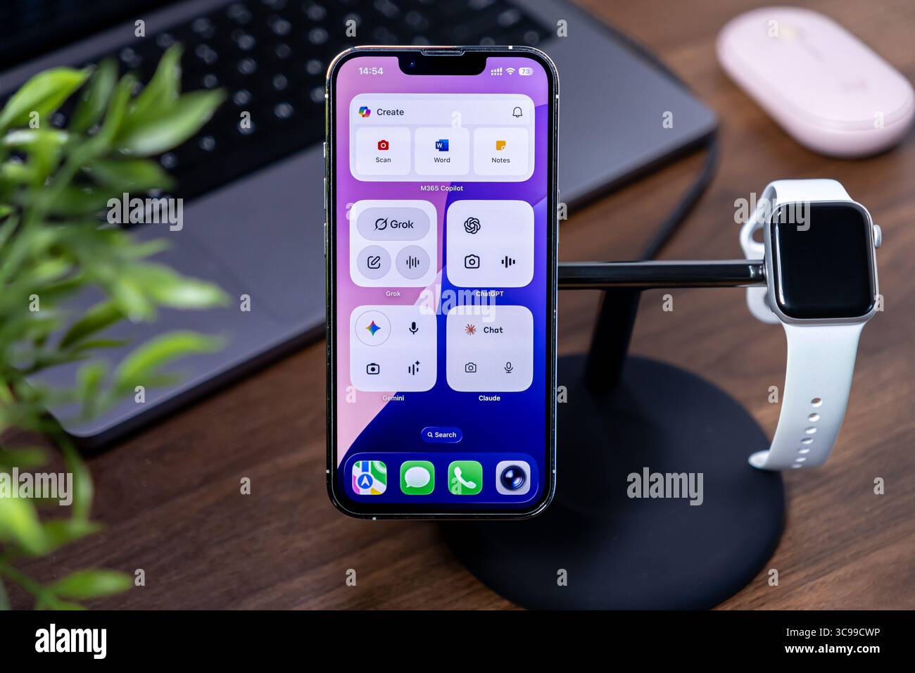 Poznan, Polonia - 29 luglio 2025: Una workstation organizzata presenta un iPhone che visualizza M365 Copilot, con ios 26 Liquid Glass Concepts Foto Stock
