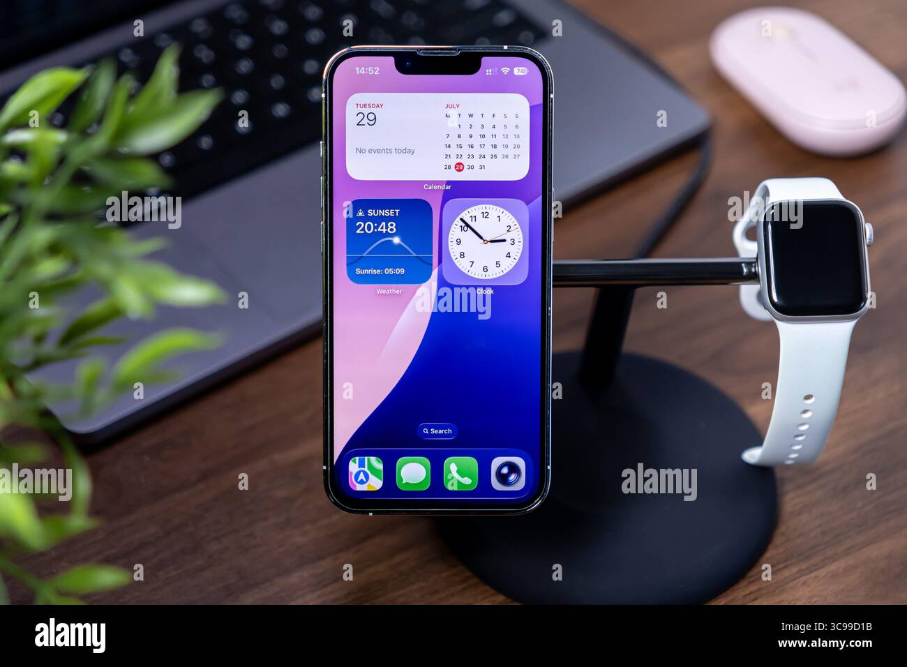 Poznan, Polonia - 29 luglio 2025: Apple iPhone presenta l'interfaccia in vetro liquido ios 26 su un elegante piedistallo, abbinato ad Apple Watch, che illustra la Foto Stock