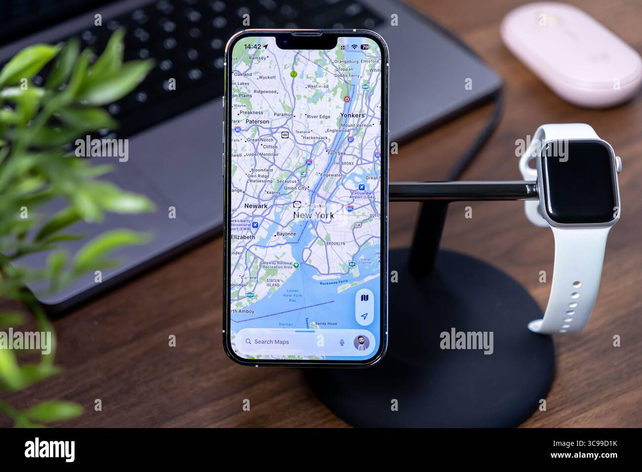 Poznan, Polonia - 29 luglio 2025: Applicazione Apple Maps su un iPhone, che visualizza le rotte di New York, un Apple Watch e un laptop nelle vicinanze, migliorando ios 26 AN Foto Stock