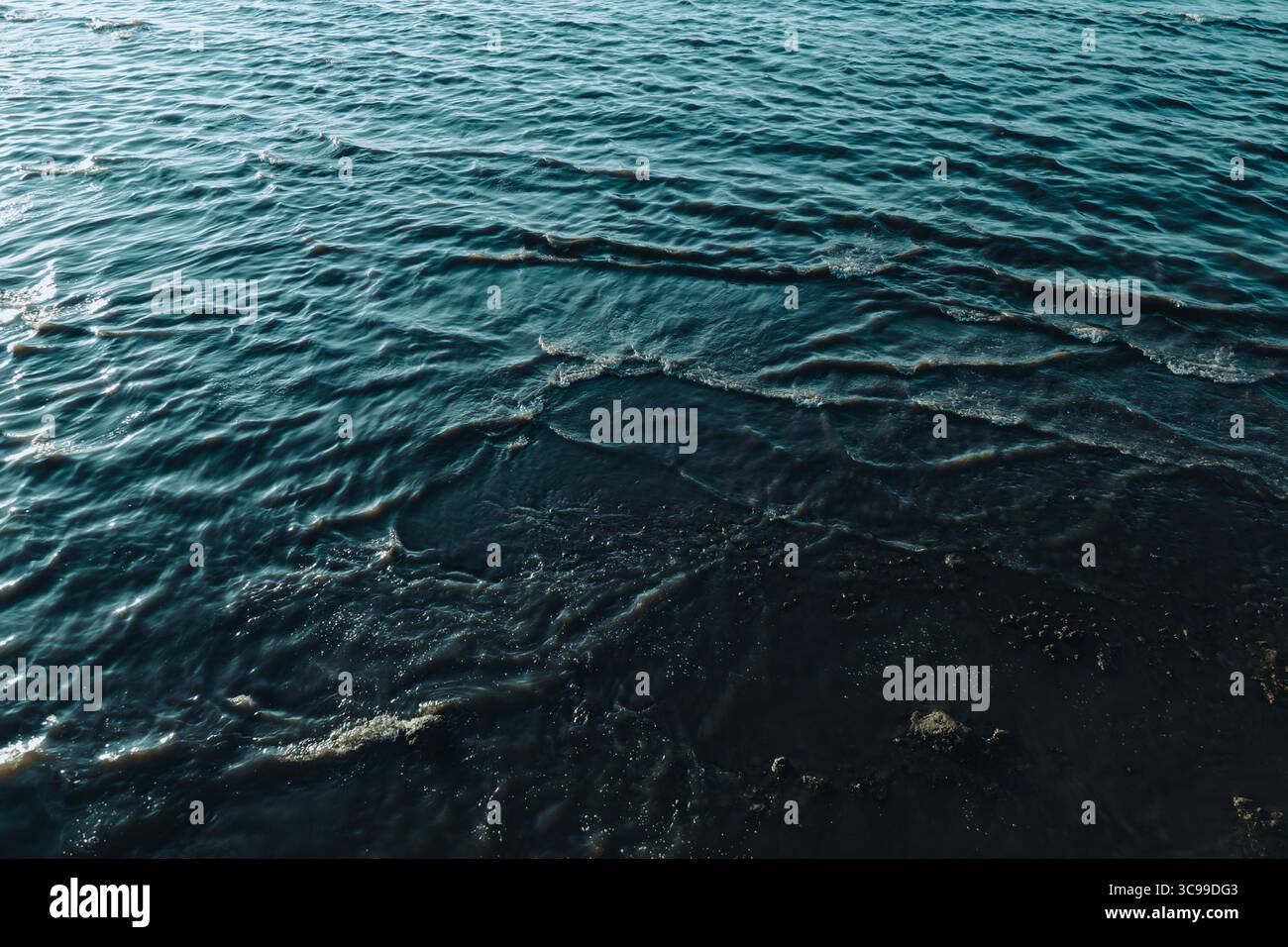 Primo piano di calme acque di mare con morbide increspature e tonalità blu scuro, catturando la bellezza tranquilla e rilassante della superficie dell'oceano Foto Stock