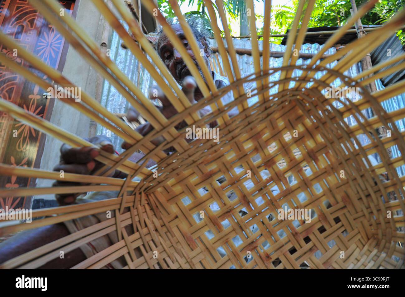 25 novembre 2022: 26 novembre 2022. Sylhet, Bangladesh: Moyna Biswas 80 anni, un'artista artigianale di canna da zucchero di Haripur, nell'area di Sylhet, sta tessendo un prodotto di canna nel suo cortile. Egli è certo che il suo erede non prenderà questo lavoro artigianale di canna da zucchero come professione, mentre i prodotti di plastica sono disponibili sul mercato a un prezzo inferiore a quello della canna da zucchero e peggiorano già il mercato. (Immagine di credito: © MD Rafayat Haque Khan/ZUMA Press Wire) Foto Stock