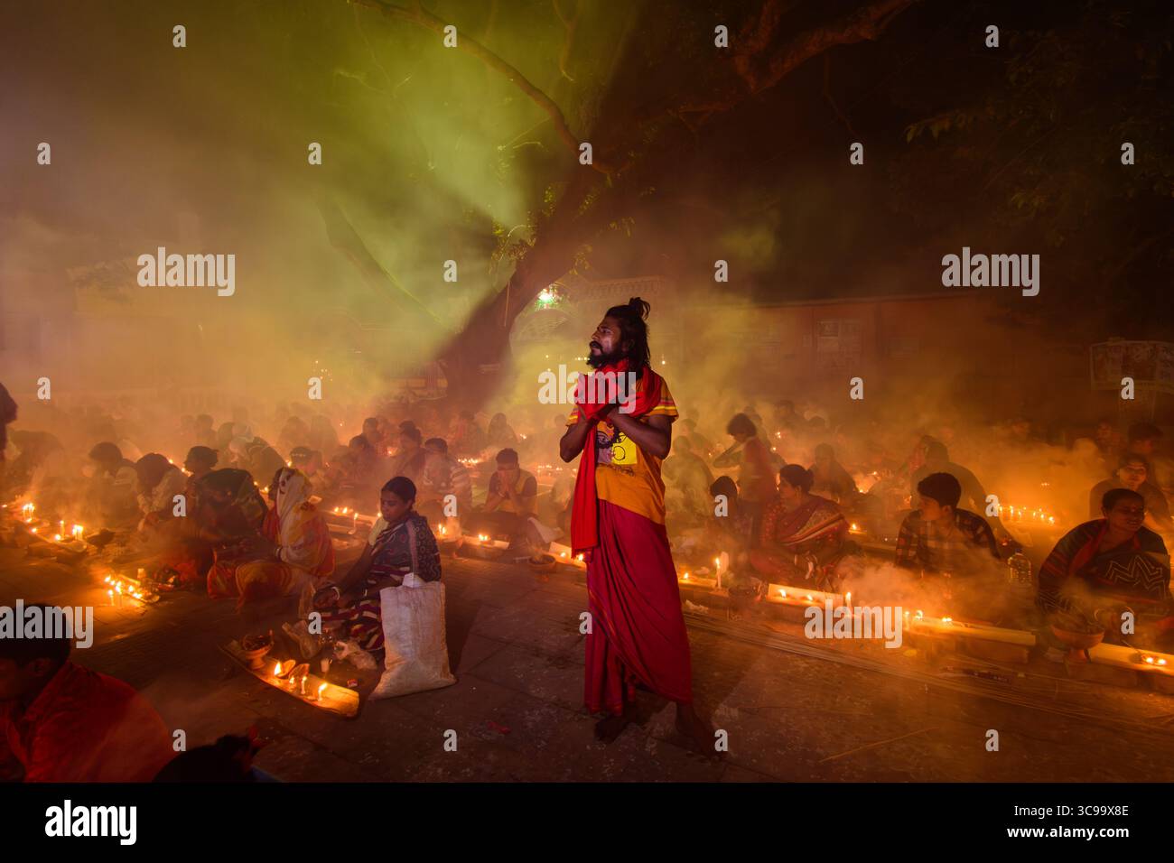 Narayanganj, Bangladesh - 11 giugno 2018: Veduta di un raduno spirituale illuminato da tenui lume di candela, figure sfocate nella foschia atmosferica, creando una scena serena ed eterea. Foto Stock