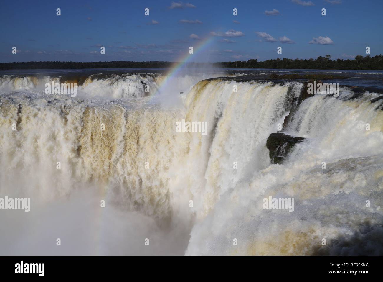 Splendida vista delle cascate di Iguazú presso la Gola del Diavolo (Garganta del Diablo) con arcobaleno sul lato argentino, sotto un cielo blu brillante in una giornata di sole. Foto Stock