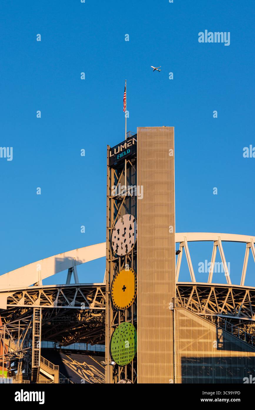 Seattle, USA - 29 luglio 2025: Vista della torre architettonica del Lumen Field che si innalza contro un cielo limpido, punteggiata da un aereo distante. Foto Stock