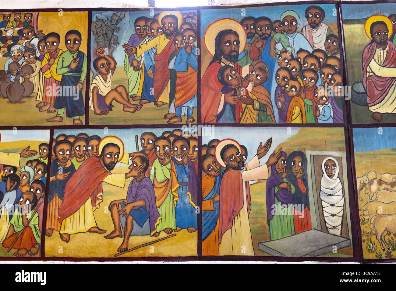 Kalacha, Kenya - 12 maggio 2022: Veduta di vivaci affreschi religiosi che raffigurano scene bibliche con toni terrosi profondi e aloni luminosi, catturando momenti di fede e comunità in una narrazione senza tempo. Foto Stock