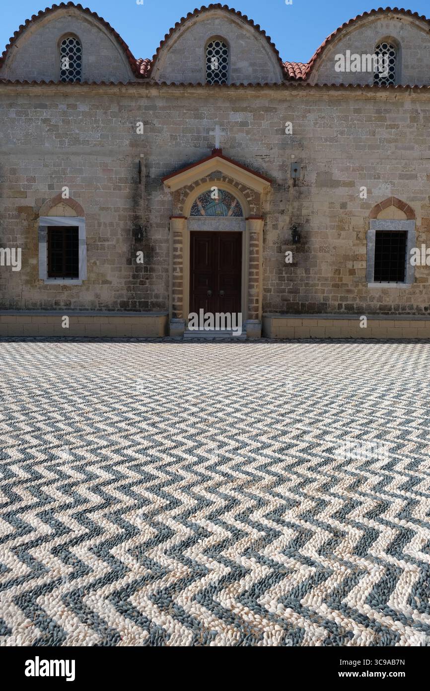 Motivo ondulato in ciottoli fuori da una chiesa greco-ortodossa nella città di Rodi Foto Stock