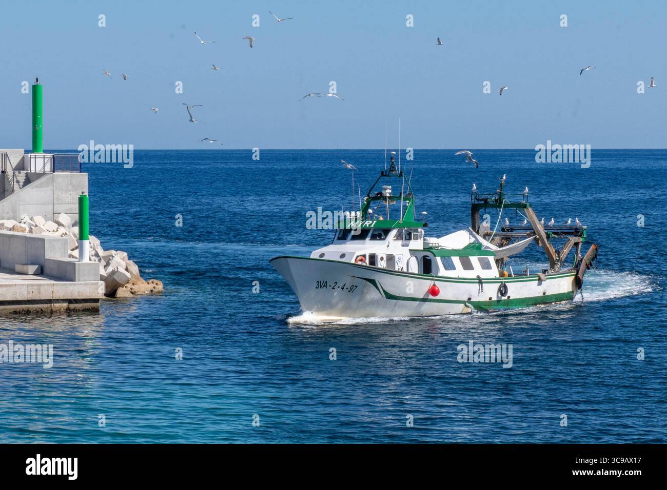 Ein Schleppnetzfischer läuft in den Hafen von Cala Ratjada ein. Foto Stock