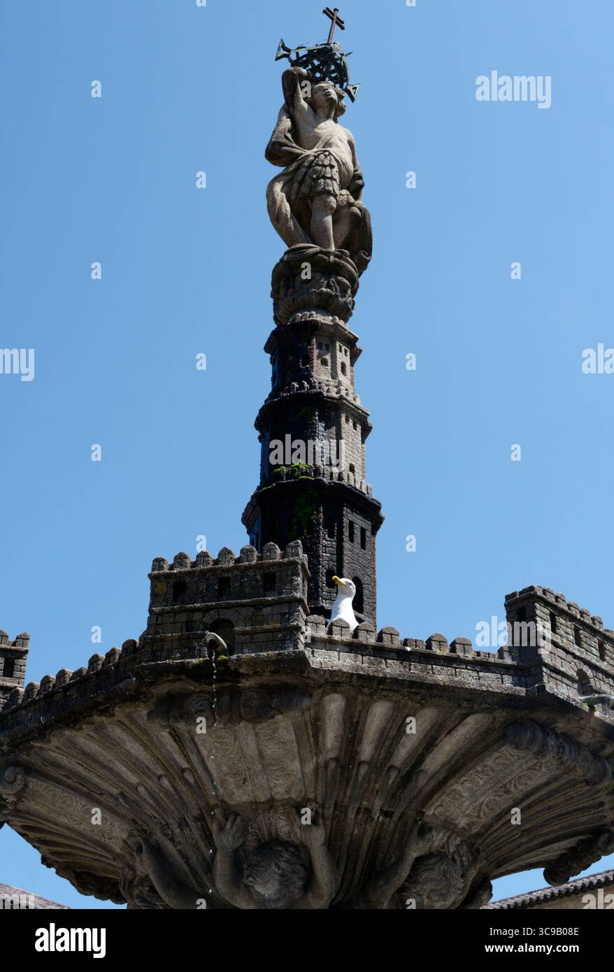 La fontana barocca "Chafariz do Castelo" con un curioso gabbiano sotto un cielo azzurro Foto Stock