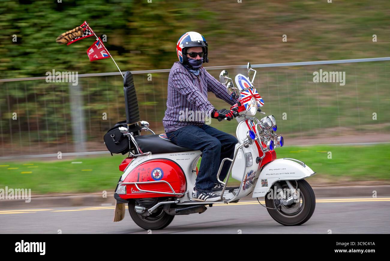 Milton Keynes,Bucks,UK - 3 agosto 2025: Uomo in sella a una Vespa Piaggio 2016 su una strada inglese Foto Stock