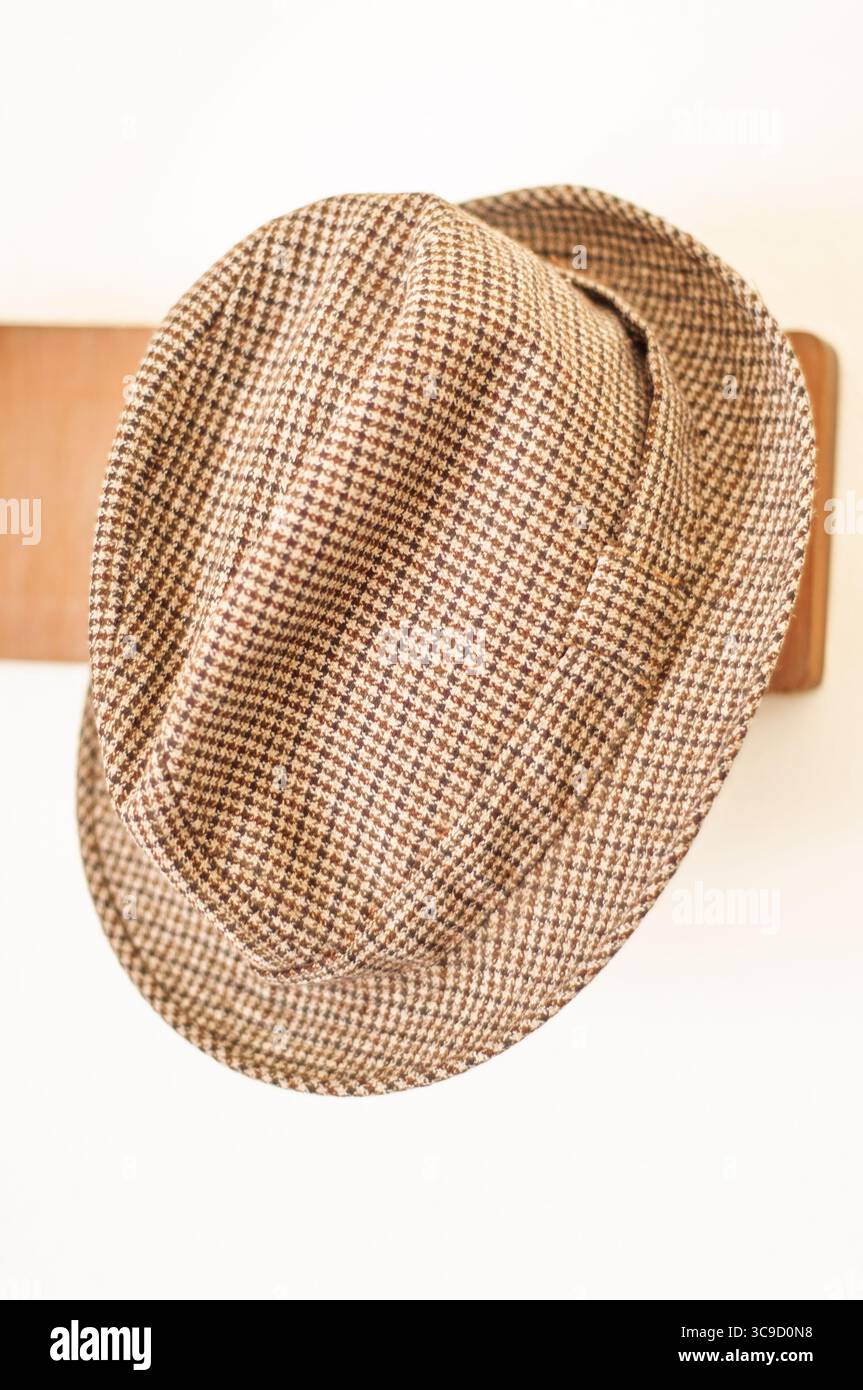 Cappello pied de poule appeso su una cremagliera di legno. Stile classico. Foto Stock