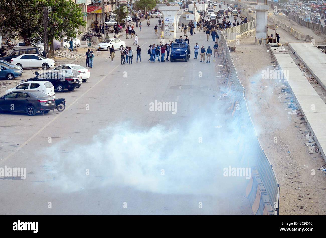 Il personale della polizia ripristina la carica del bastone e il gas lacrimogeno per respingere i manifestanti durante la manifestazione di protesta di Tehreek-e-Insaf (PTI) per il rilascio del fondatore del PTI Imran Khan e di sua moglie Bushra Bibi, vicino edificio del centro amministrativo presso University Road a Karachi martedì 5 agosto 2025. Foto Stock
