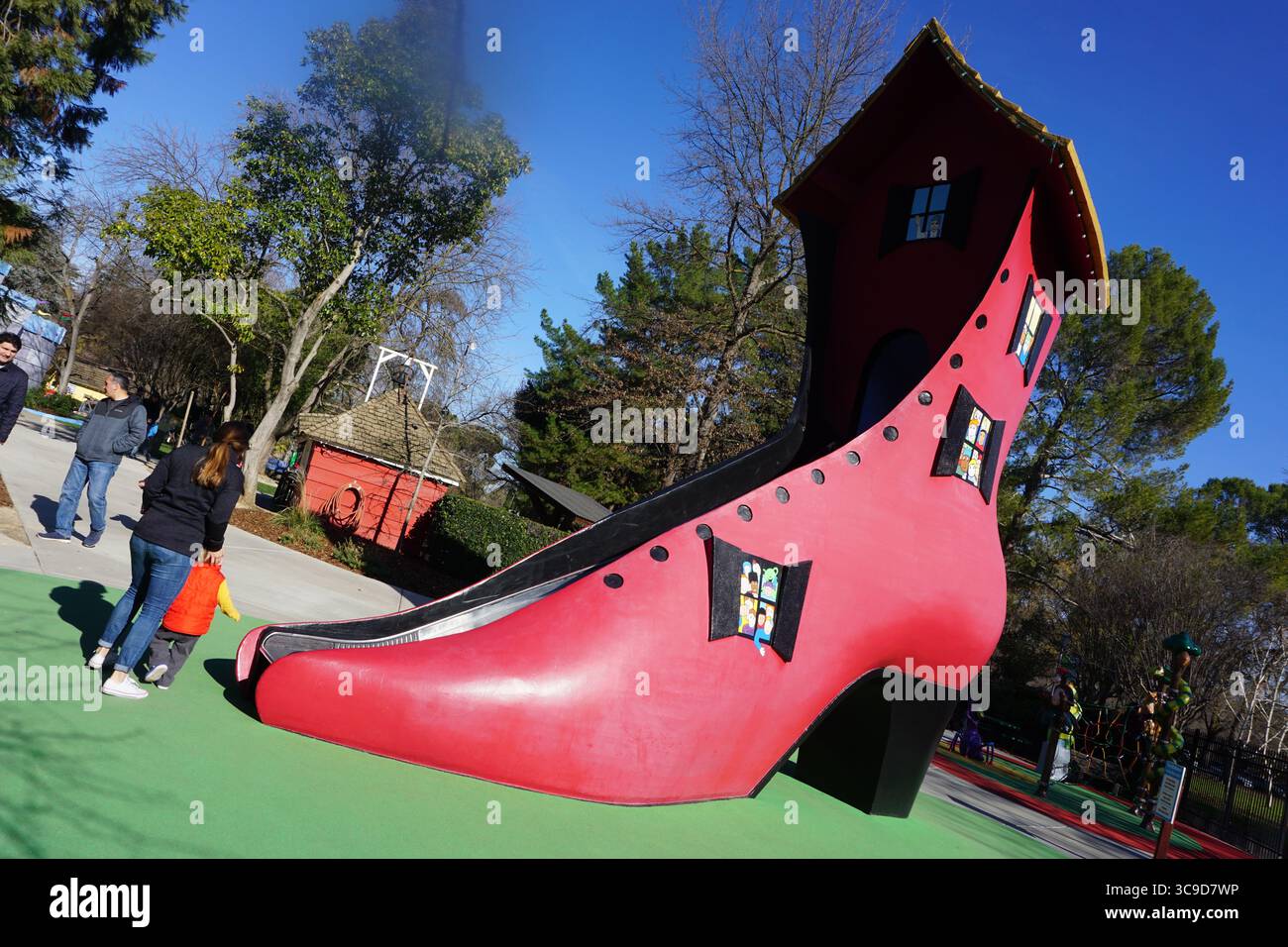 Una stravagante struttura rossa a tacco alto si è trasformata in un'attrazione da scivolo, ispirata alla classica filastrocca "c'era una vecchia donna che viveva Foto Stock