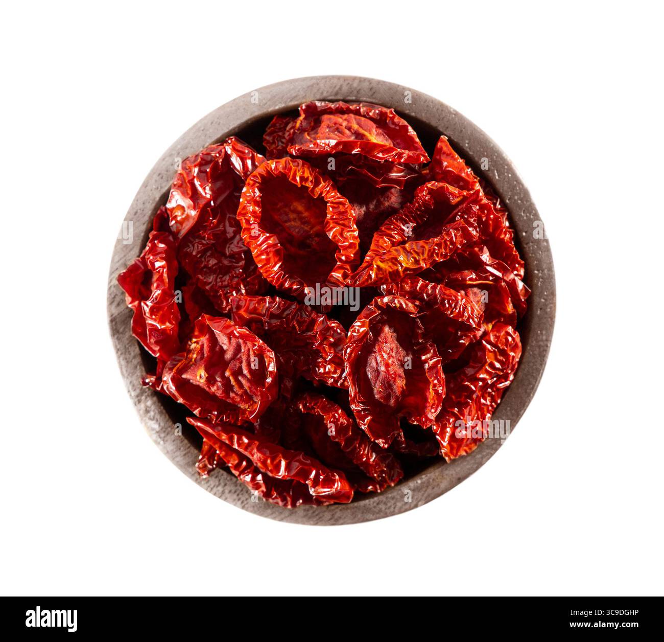 Pomodoro essiccato in un recipiente di legno. Tomatoe essiccato isolato su fondo bianco. Mazzo di tomatoe essiccato su sfondo bianco. Foto Stock