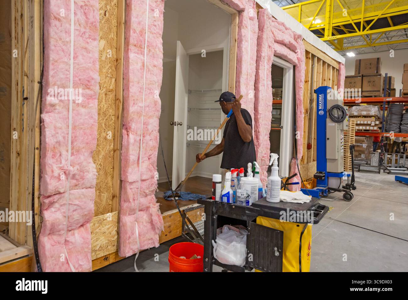 Romulus, Michigan - i lavoratori costruiscono appartamenti nella fabbrica di Ginosko Modular utilizzando metodi di costruzione modulari. Un'unità modulare finita viene pulita Foto Stock