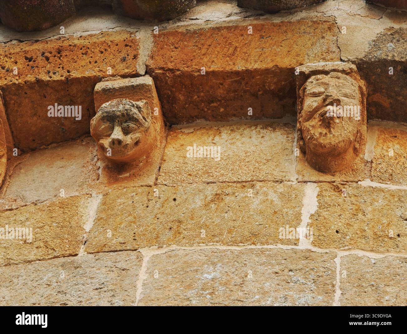Teste di pietra umane e animali adornavano l'eremo romanico di Calatañazor, mostrando iconografia rurale medievale e artigianato. Foto Stock