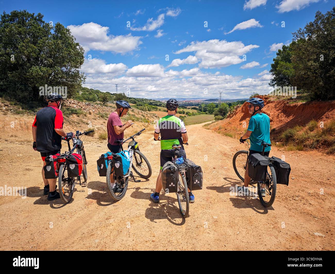 Soria, Spagna, 7 luglio 2025, i ciclisti anziani fanno una pausa vicino a Soria, Spagna, godendosi le viste mozzafiato della campagna castigliana e condividendo il loro jour Foto Stock