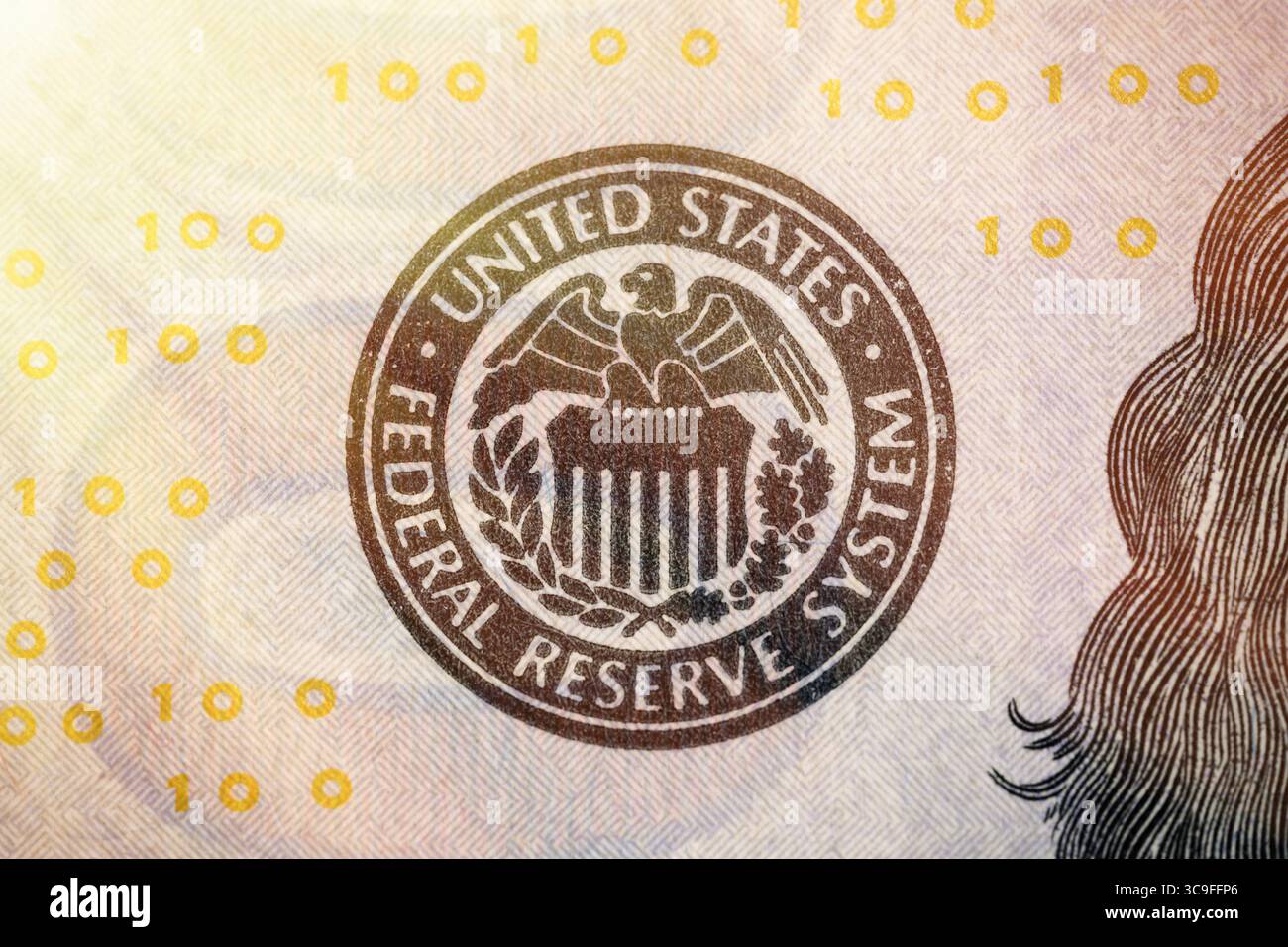 Simbolo del Federal Reserve System degli Stati Uniti dalla banconota da cento dollari. Primo piano con effetto raggi solari. Foto Stock