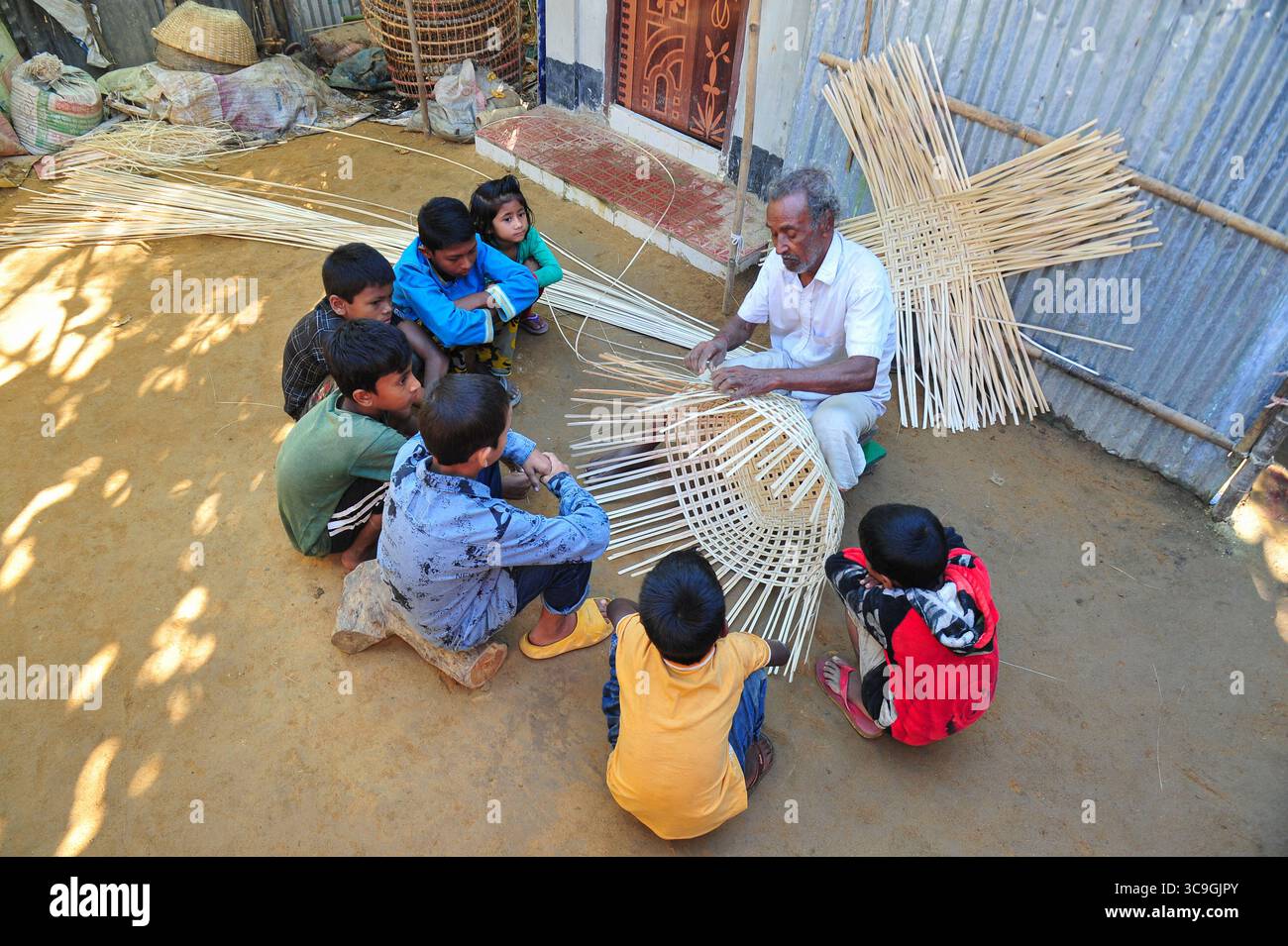 25 novembre 2022: 26 novembre 2022. Sylhet, Bangladesh: Moyna Biswas 80 anni, un'artista artigianale di canna da zucchero di Haripur, nell'area di Sylhet, sta tessendo un prodotto di canna mentre i suoi eredi stanno osservando e imparando accanto a lui. Egli è certo che il suo erede non prenderà questo lavoro artigianale di canna da zucchero come professione, mentre i prodotti di plastica sono disponibili sul mercato a un prezzo inferiore a quello della canna da zucchero e peggiorano già il mercato. (Immagine di credito: © MD Rafayat Haque Khan/ZUMA Press Wire) Foto Stock