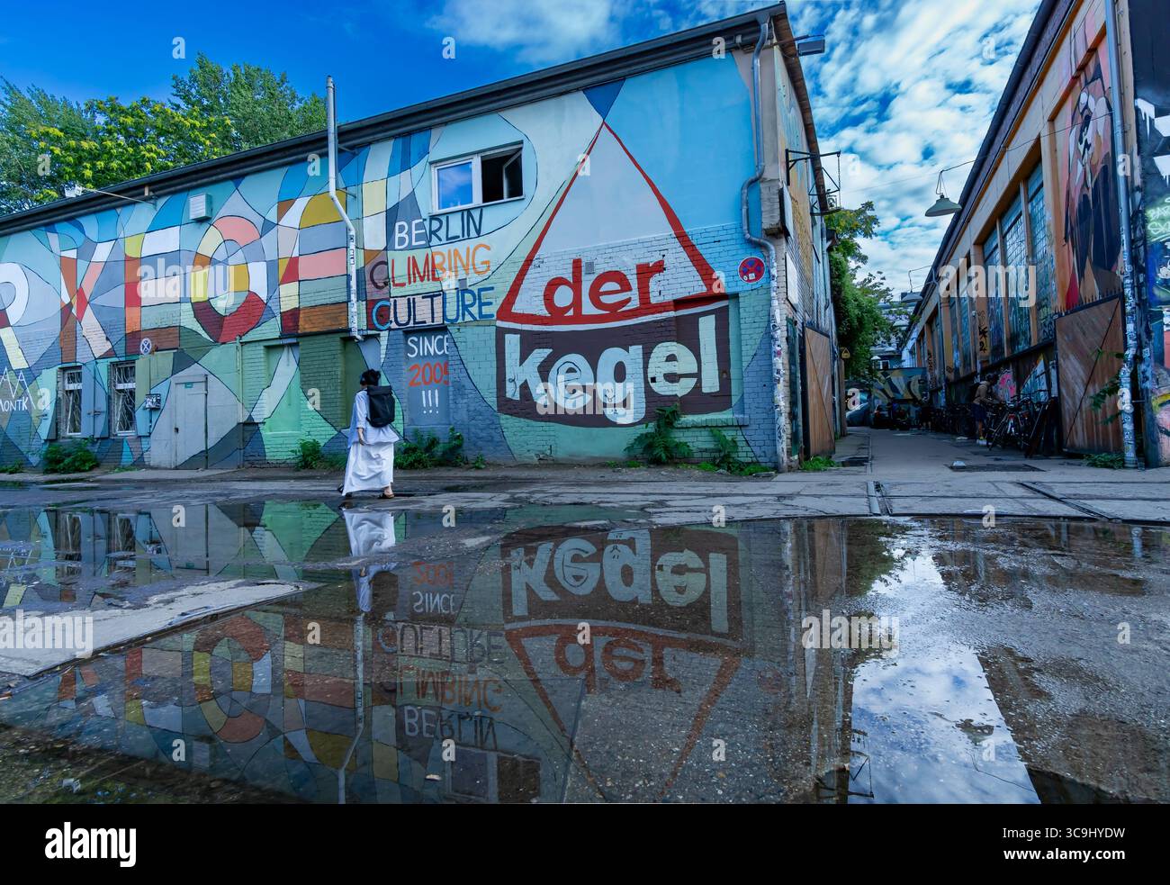 Colorato murale che pubblicizza la torre di arrampicata Der Kegel a Berlino Friedrichshain, con riflessi in una pozzanghera dopo la pioggia. Foto Stock