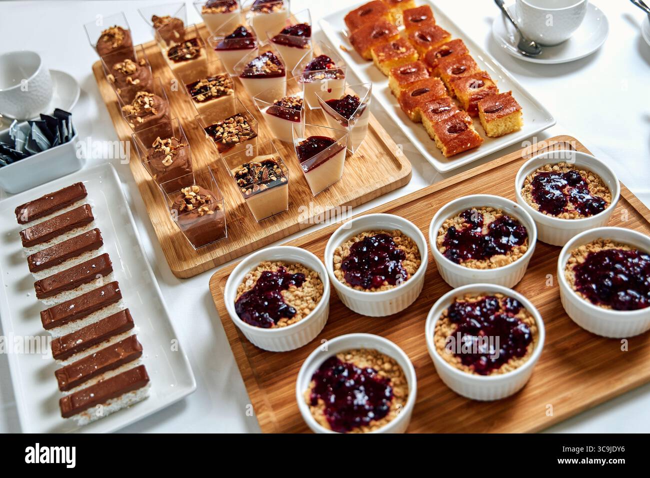 Un delizioso assortimento di dessert assortiti con budini cremosi, crostate di frutta e deliziosi dolci, perfetti per qualsiasi celebrazione o riunione Foto Stock