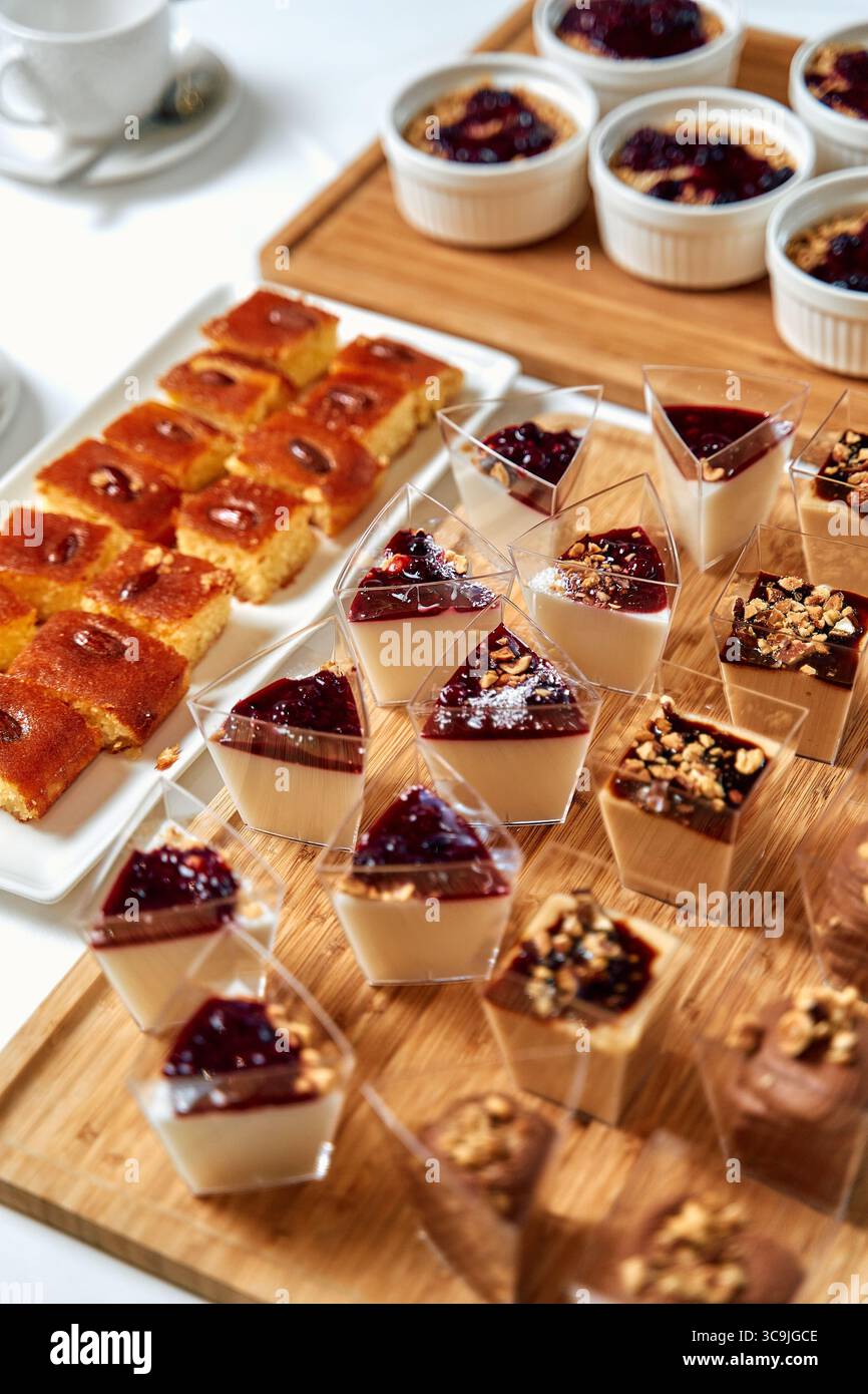 Una sontuosa esposizione di deliziosi dessert con budini cremosi, gelatine dolci e torte umide perfette per qualsiasi celebrazione o riunione Foto Stock