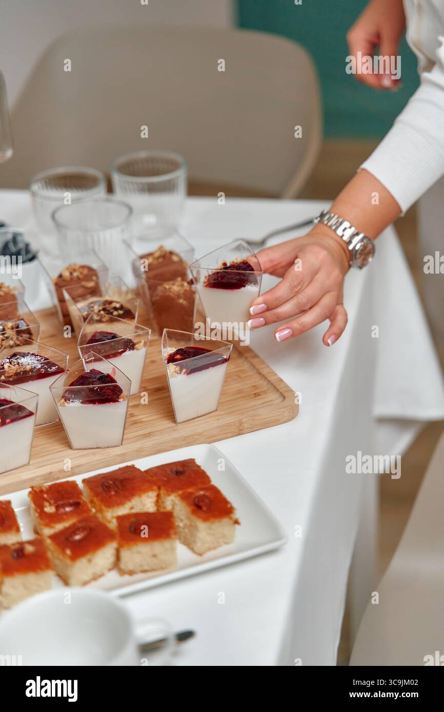 Deliziosi dessert esposti su un tavolo con budini cremosi e dolci dolci per una celebrazione speciale o un raduno Foto Stock