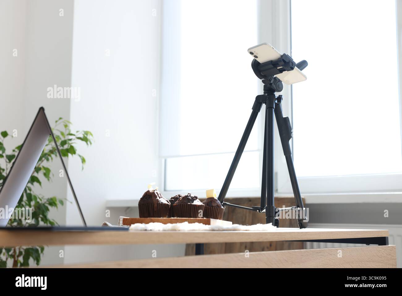 Sparare muffin al cioccolato con lo smartphone in studio. Fotografia gastronomica professionale Foto Stock
