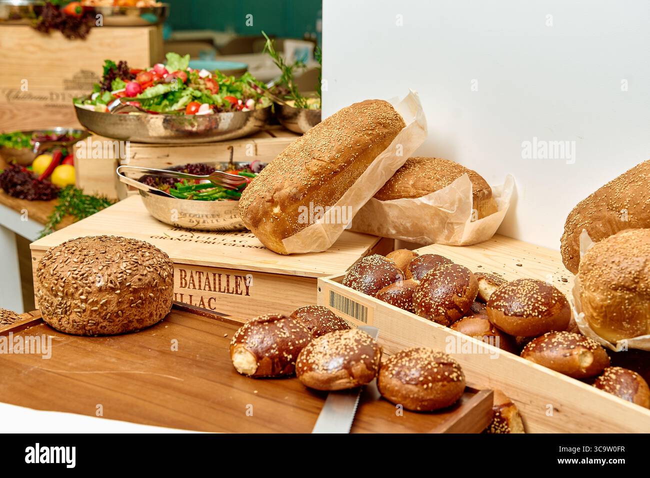 Una bella mostra di pane artigianale e insalate fresche che mostrano creatività culinaria e ingredienti naturali in un ambiente Gourmet Foto Stock